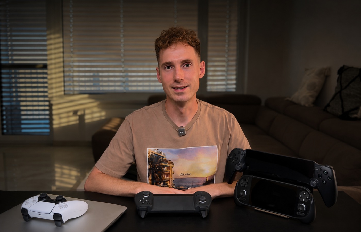 Denis from Pixelayer with handheld gaming devices and PlayStation controllers
